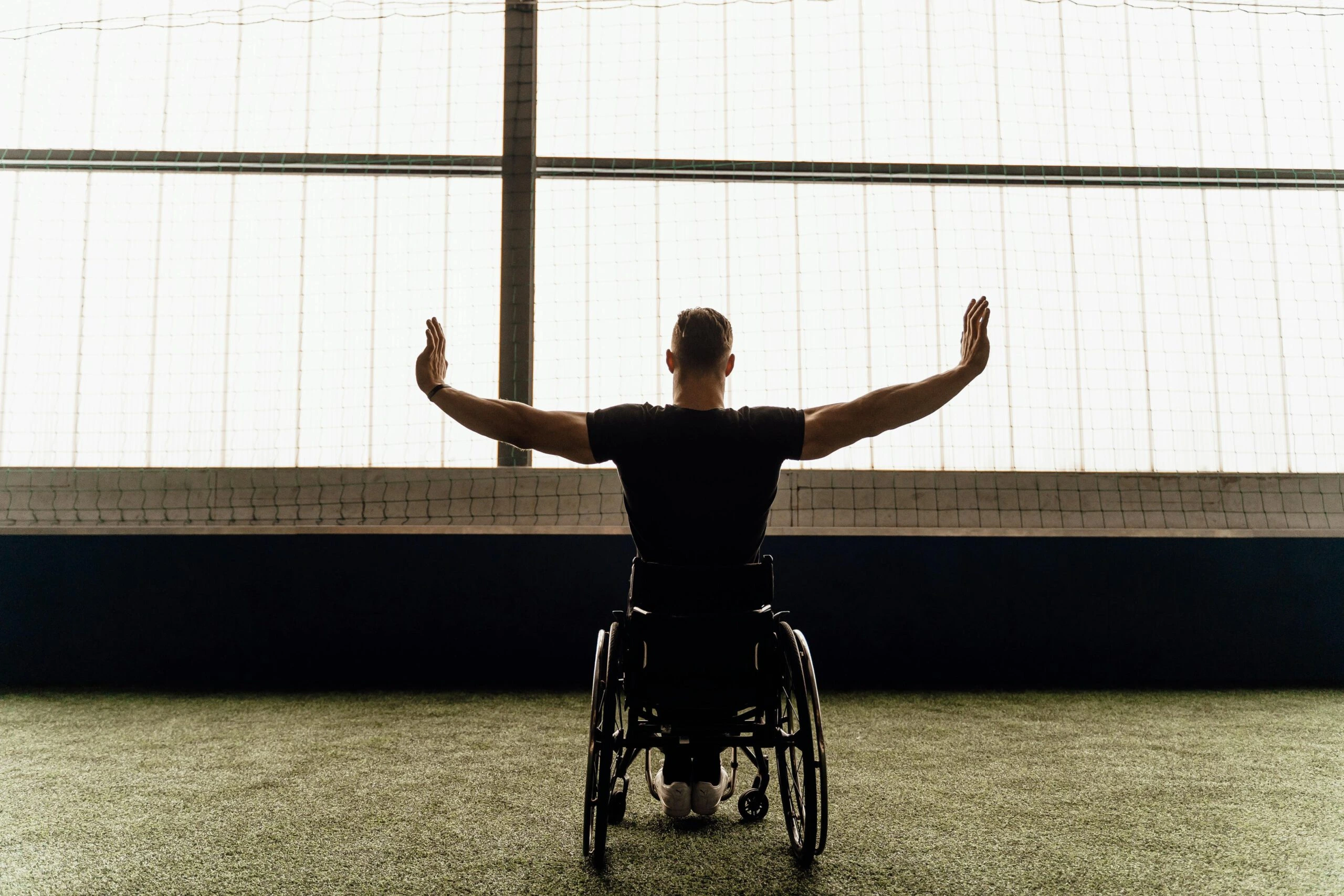 Ein Sportler im Rollstuhl macht Dehnübungen, um sich auf das Training vorzubereiten.